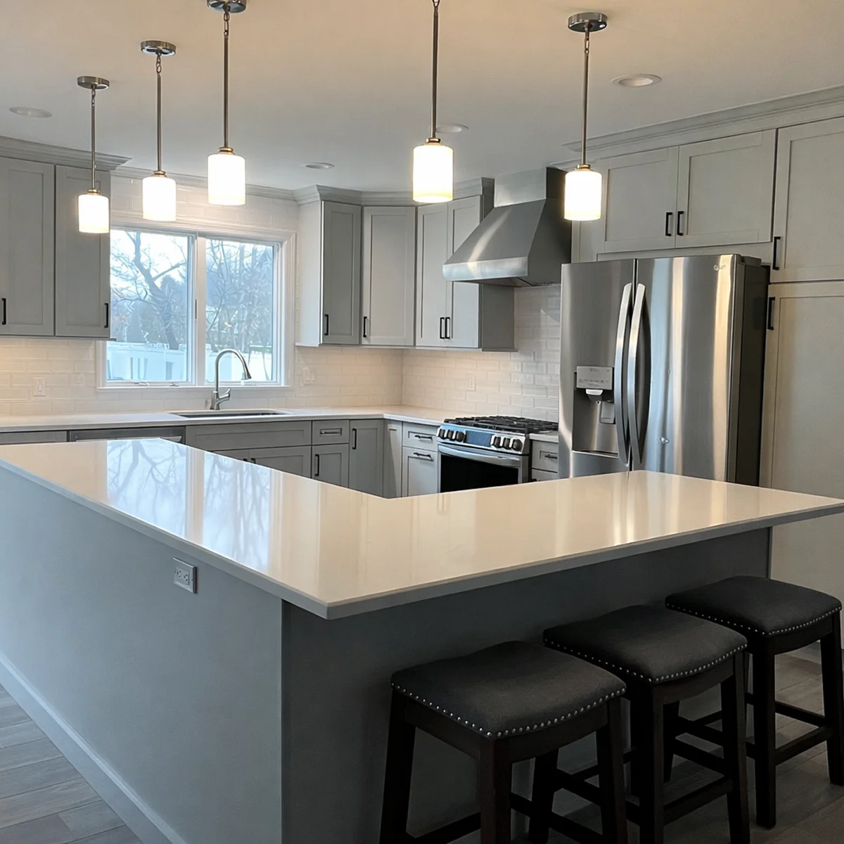 Gray kitchen peninsula with pendant lights