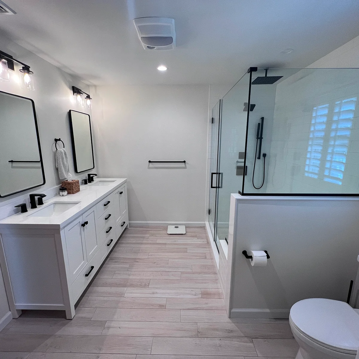White double vanity with black frame shower