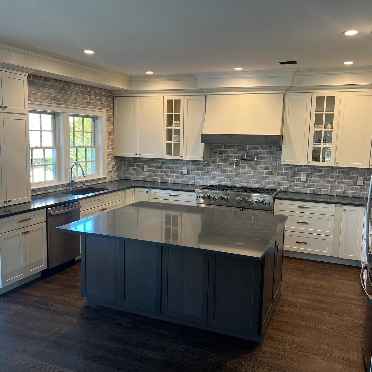 White kitchen with charcoal island and brick backsplash