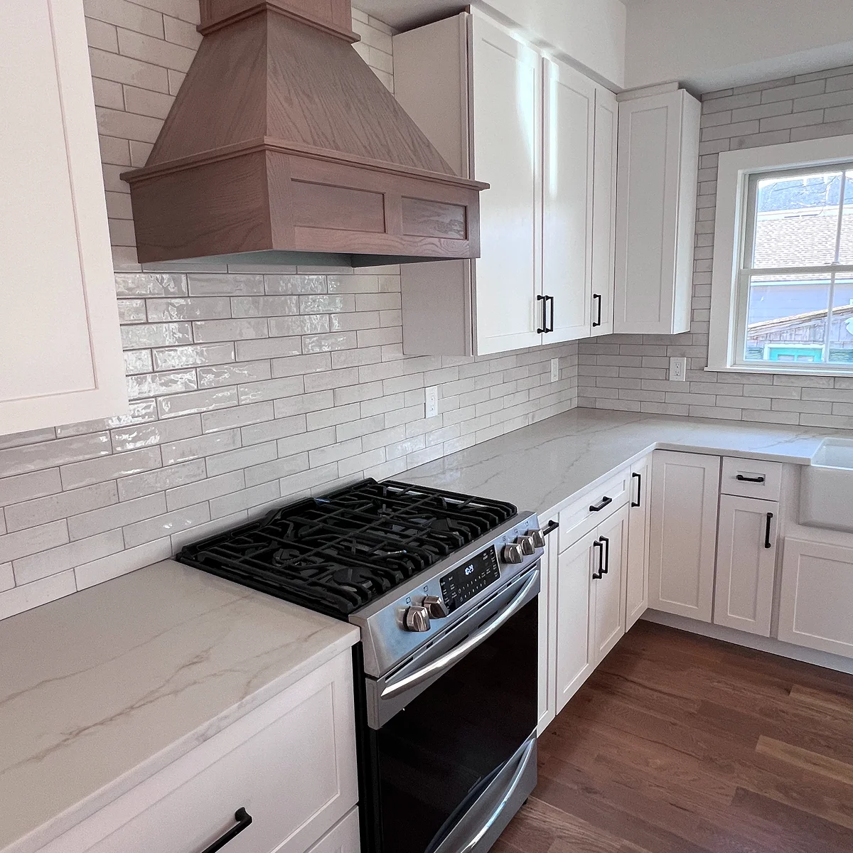 White kitchen with natural wood range hood