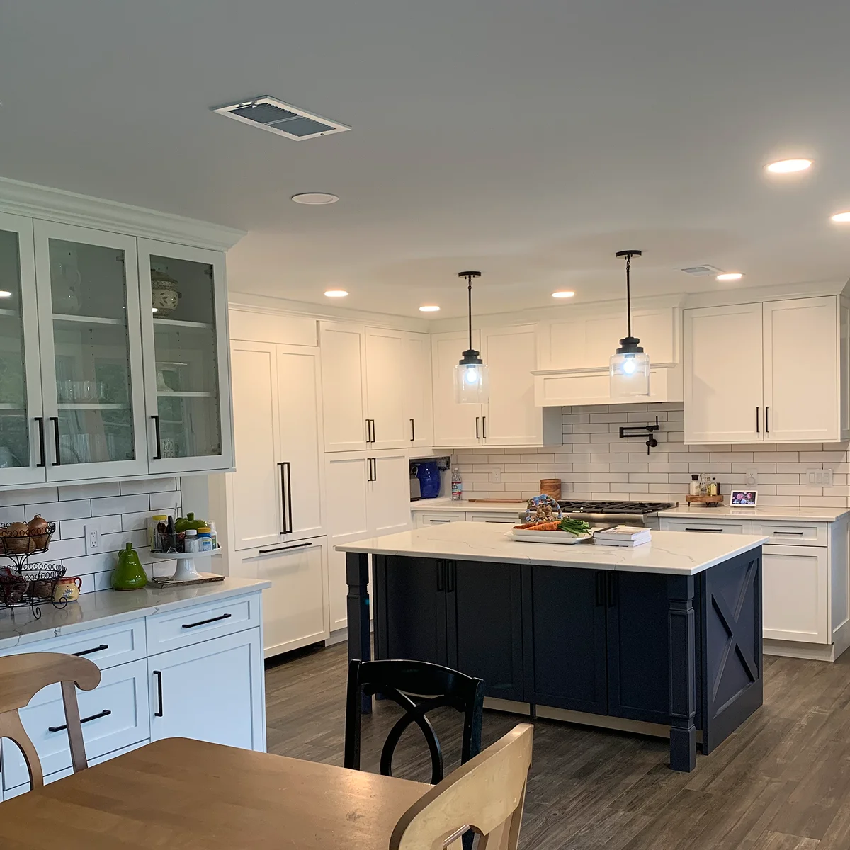 White kitchen with navy island and glass cabinets