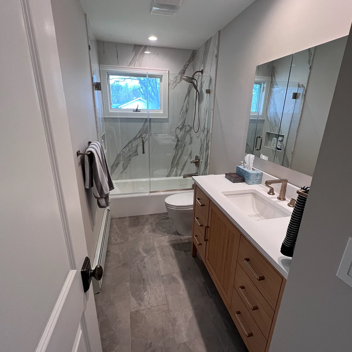 Wood vanity and marble shower bathroom